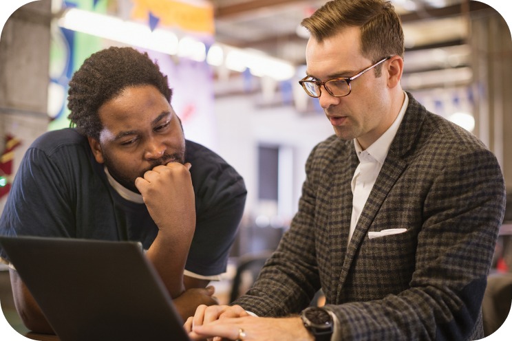 Two people looking at a laptop screen