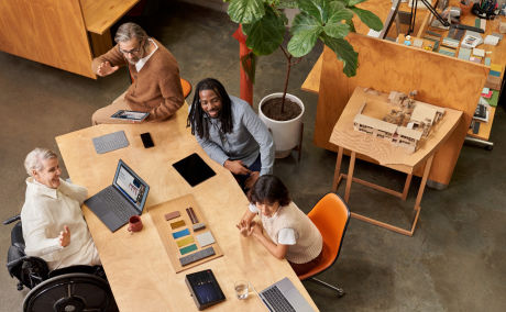 Group of coworkers smiling and having a discussion at a conference table
