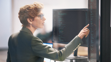 A person touching a vertical computer screen 