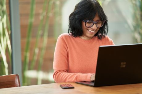 Woman happily working from laptop