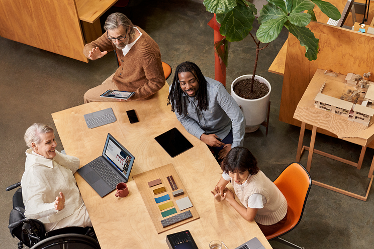 Group of coworkers smiling and having a discussion at a conference table