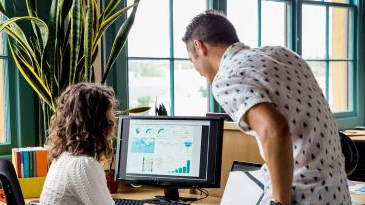 Two people collaborating on work at a computer