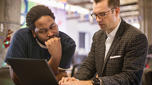 Two people looking at a computer