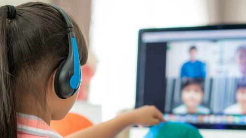 A girl wearing a headphone for a meeting via computer screen