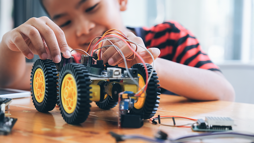 A boy constructing an electric toy car