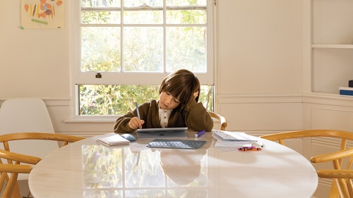 A boy is using a tablet on a table