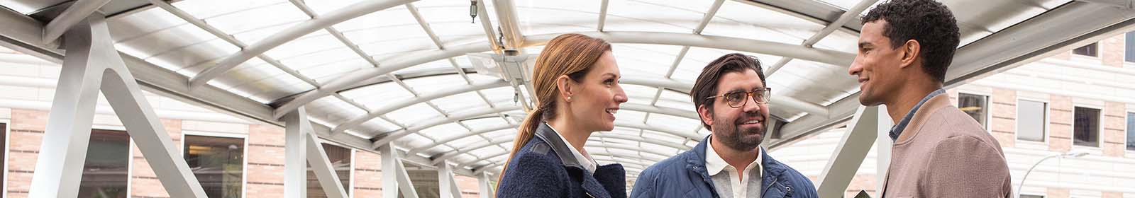 A group of people talk in a covered walkway