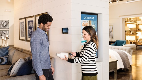 A retail worker demonstrating an embedded/IoT device