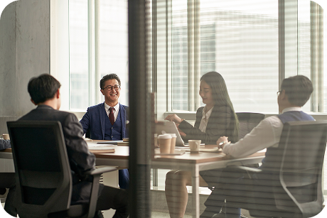 Four people sit in a conference room.
