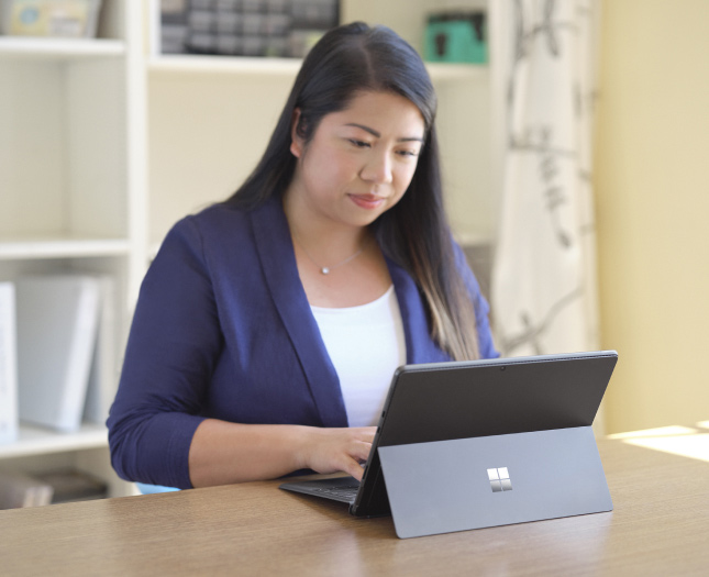 A professional works on a laptop at the office