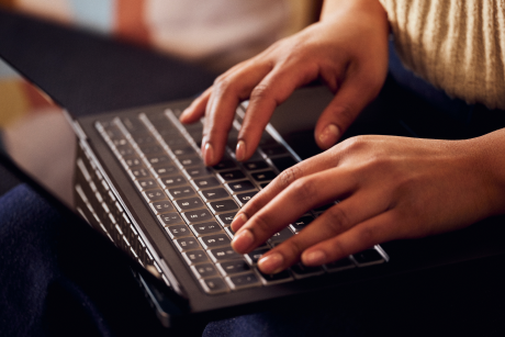 A close up photo shows a person typing on a keyboard.
