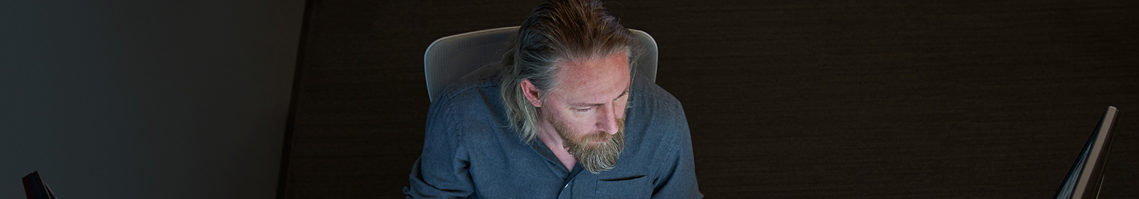 A man looks at an offscreen monitor