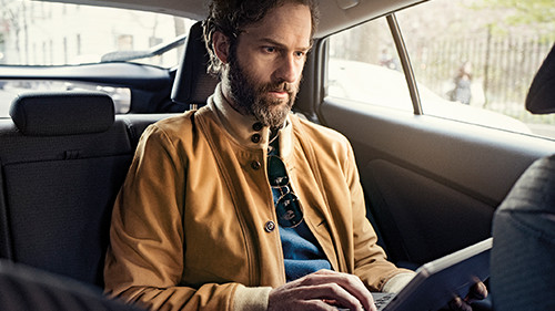 Man working in back of cab on tablet
