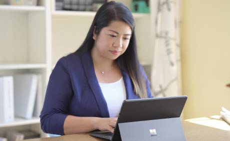 A professional works on a laptop at the office