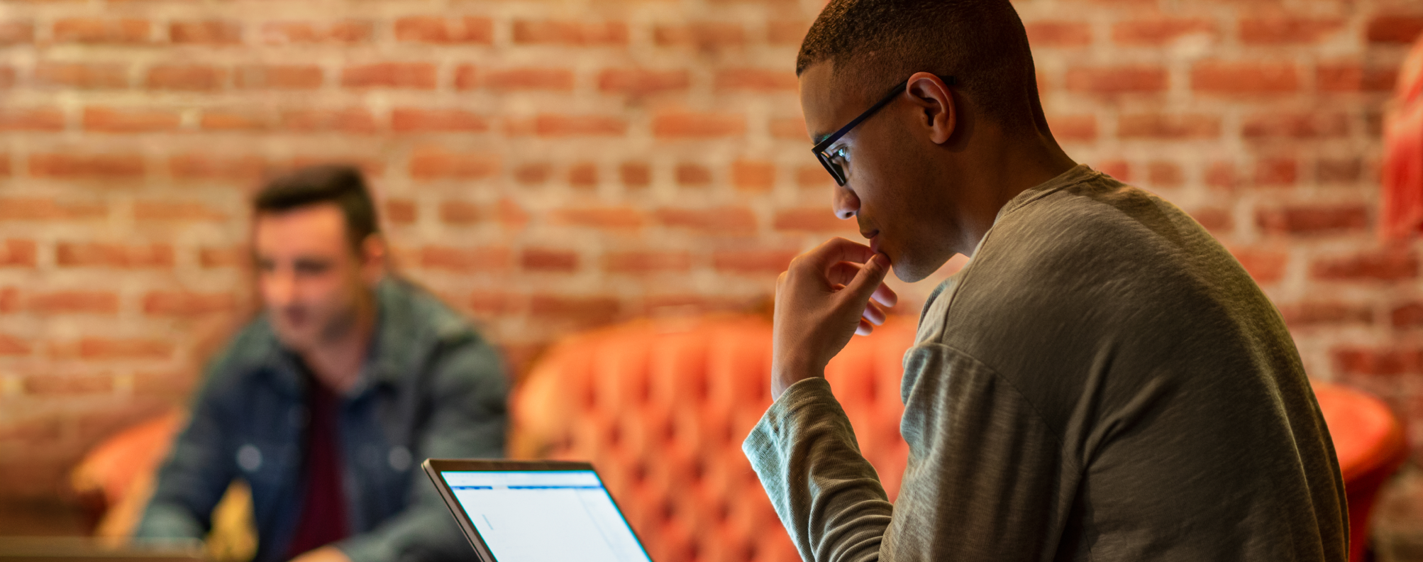 A person looks at their laptop in an office setting.