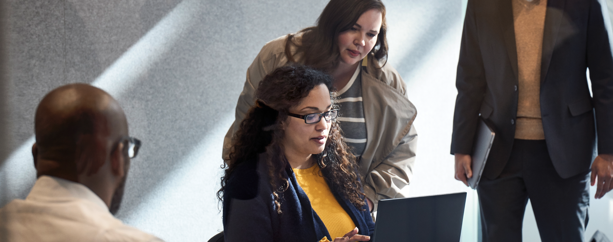 Two colleagues viewing a laptop screen in an office.