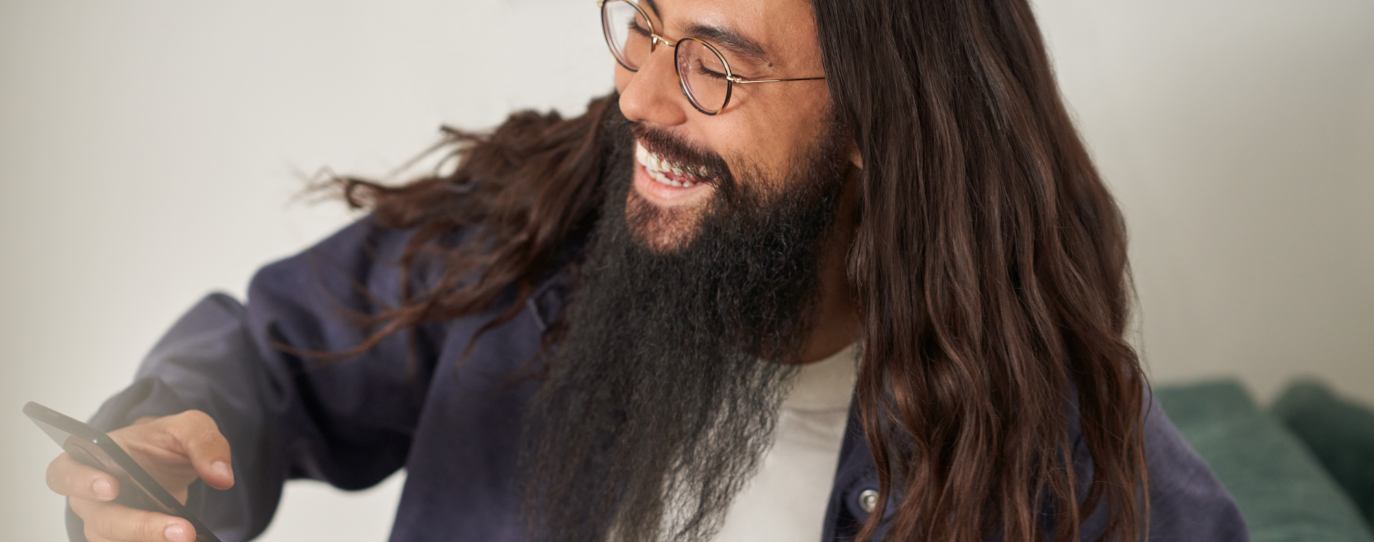 Person smiling and holding a mobile device.