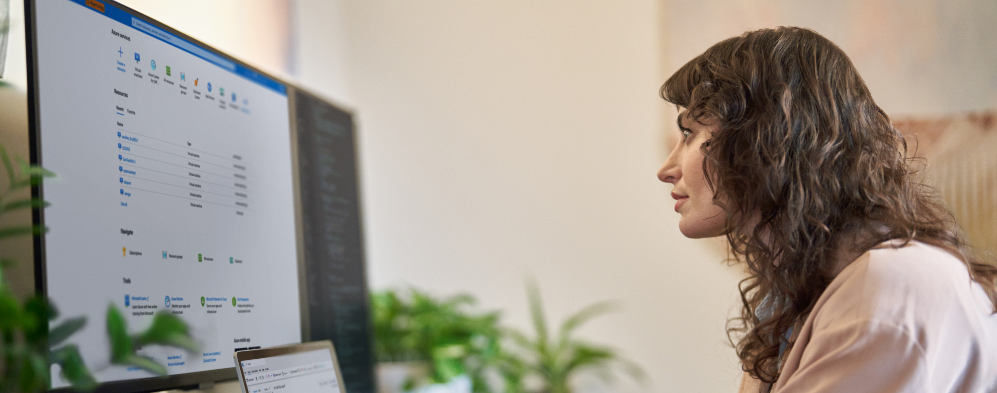 A knowledge worker sitting at a desk using a laptop and an external monitor.