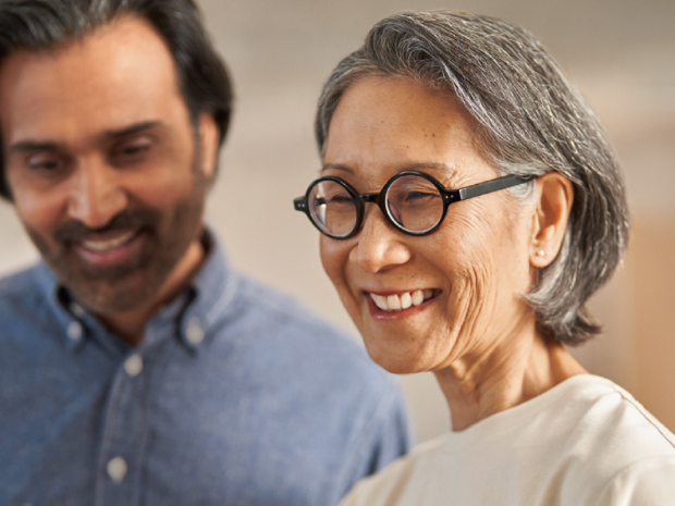 Two people smiling as they look at something together.