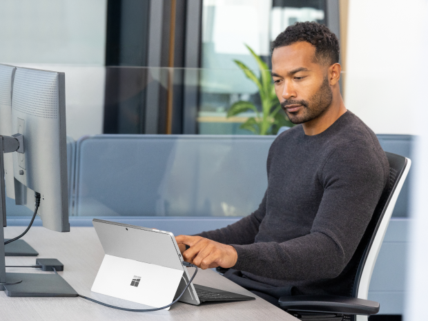 A person in an office cubicle looking at the screen of a Copilot+ PC.