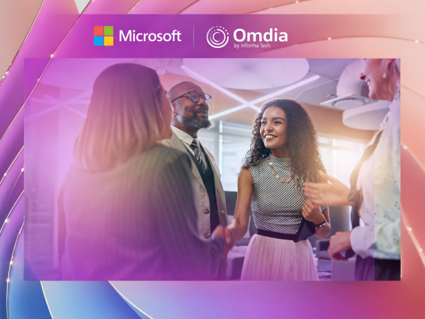 Business professionals collaborating in a modern office setting with Microsoft and Omdia branding displayed above.
