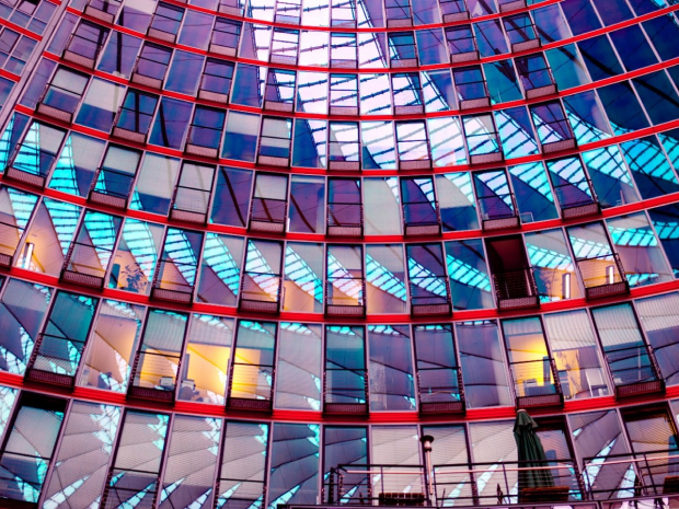 Modern glass building with reflective geometric patterns and vibrant colors.