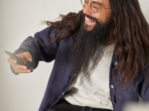 Person smiling and holding a mobile device.