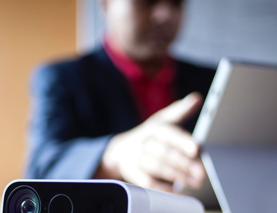 A man works on a mobile device at a desk
