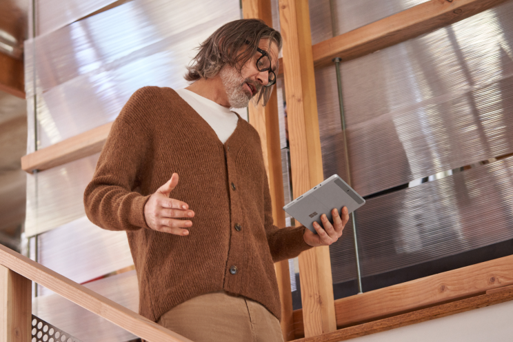 Person walking down stairs while using a tablet.