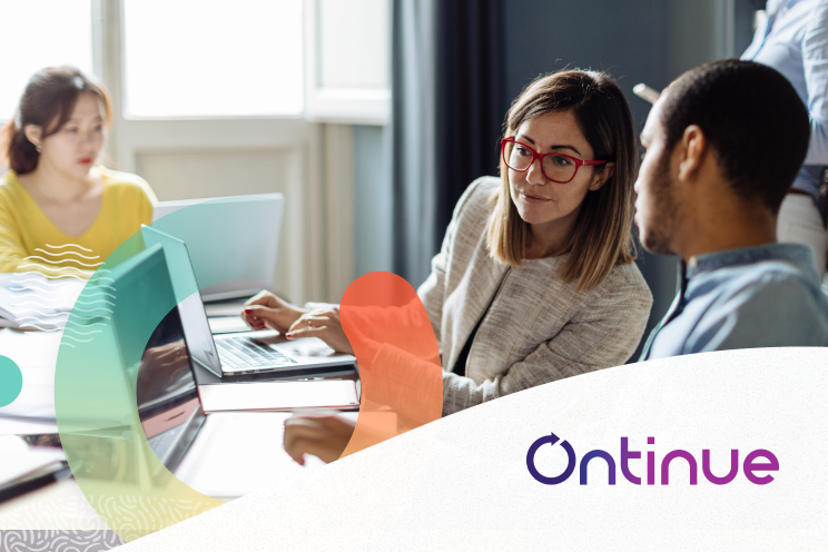 People in an office looking at each others laptop screens