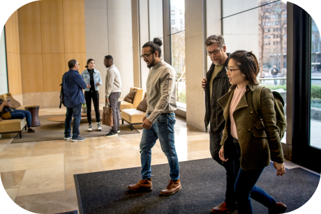 Three people entering a lobby.