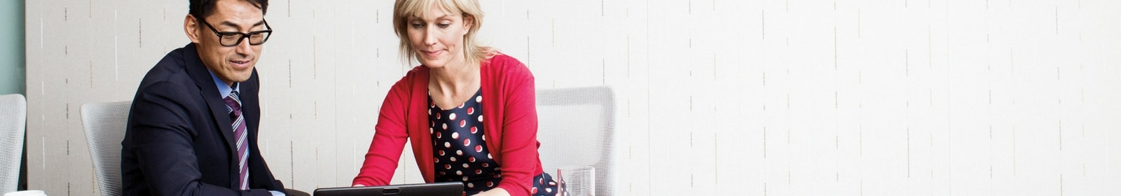 A man and a woman work together on a computer