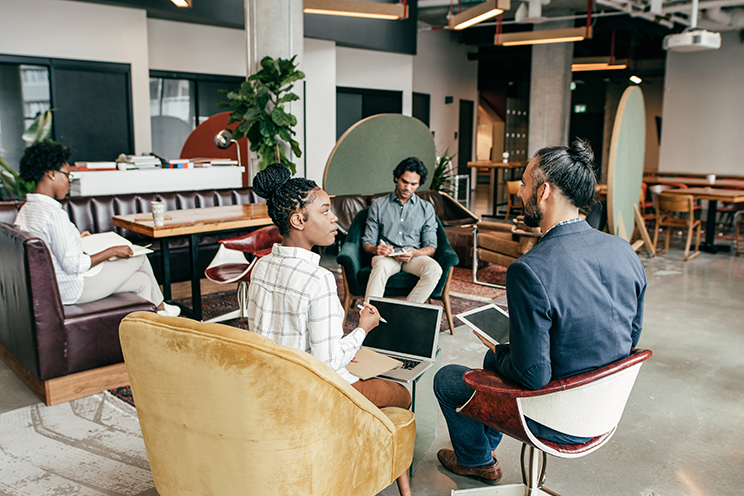 Four people sitting and chatting in a common area