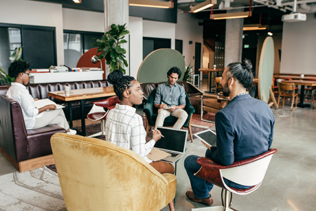 Four people sitting and chatting in a common area