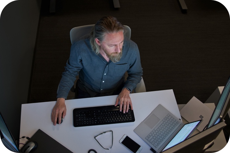 A person is viewed from above working on a laptop