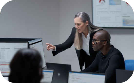 A person points to a computer where another person sits