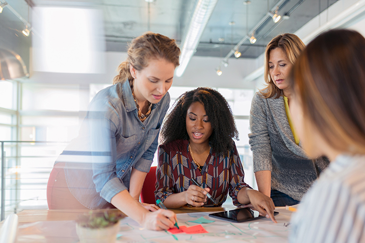 A group of people in an office working around a table