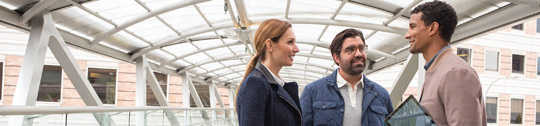 Male and female colleagues chatting on an office skybridge