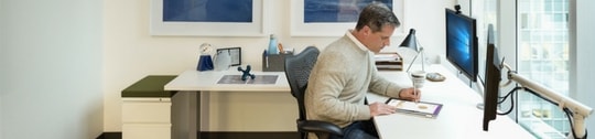 Man sitting at desk works on a tablet