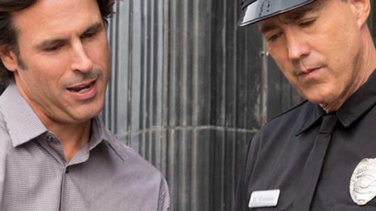 Man and police officer looking at tablet