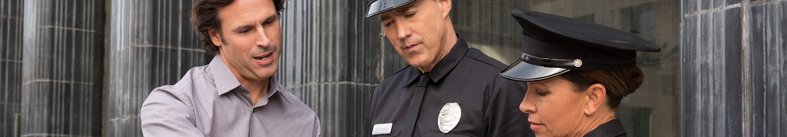 Two police officers and a man looking at a tablet