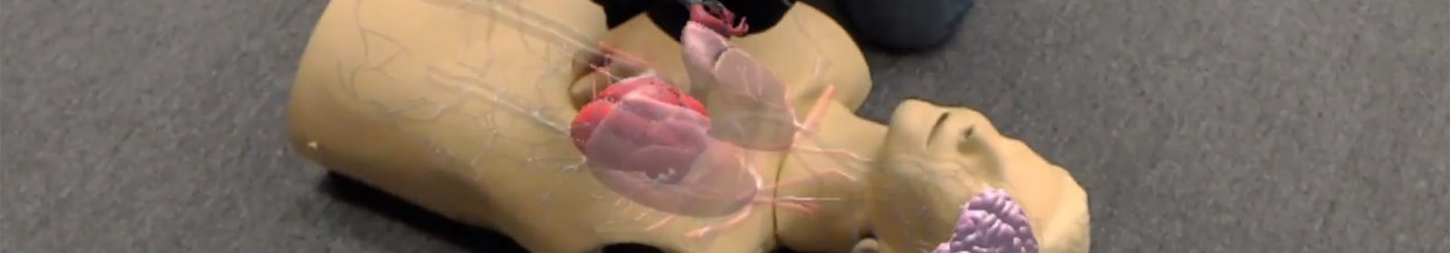 A student trains on a CPR dummy