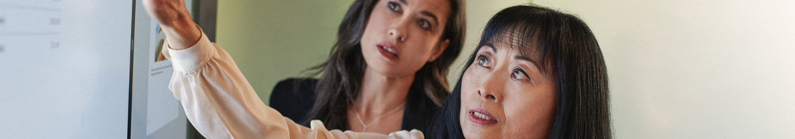 Two women collaborate during a presentation