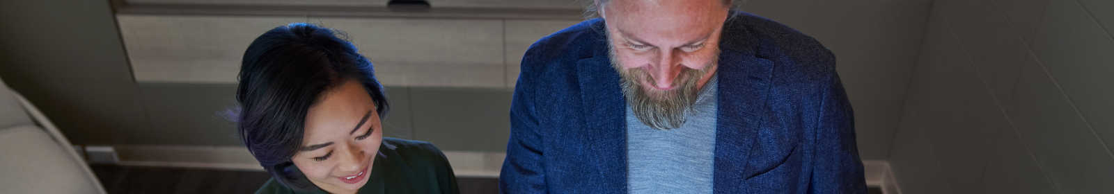 two people looking down at screen