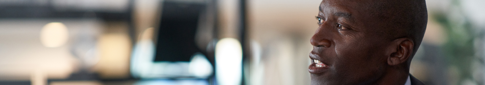 Man in an office speaking with someone out of frame