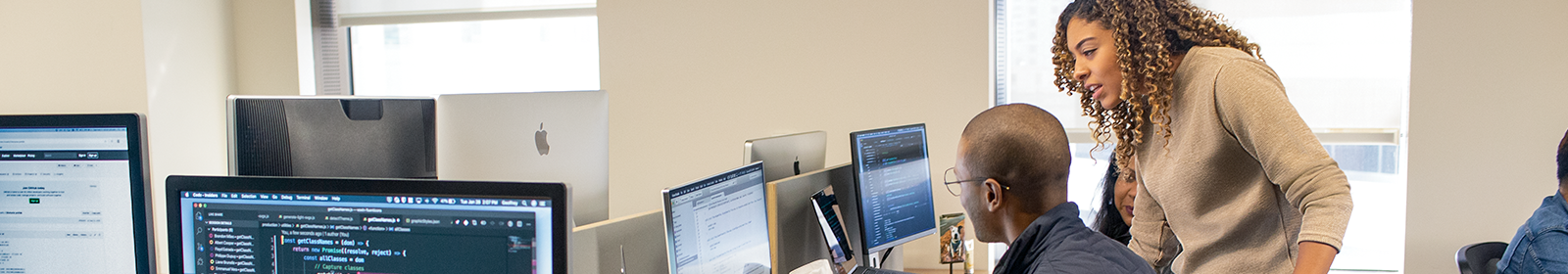 Three people look at a computer screen