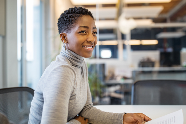 Person seated in an office smiling.