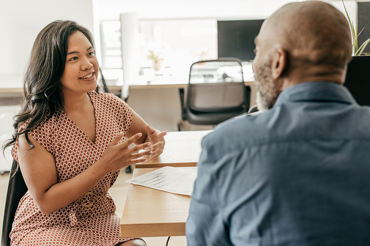 Two people having a conversation at a desk