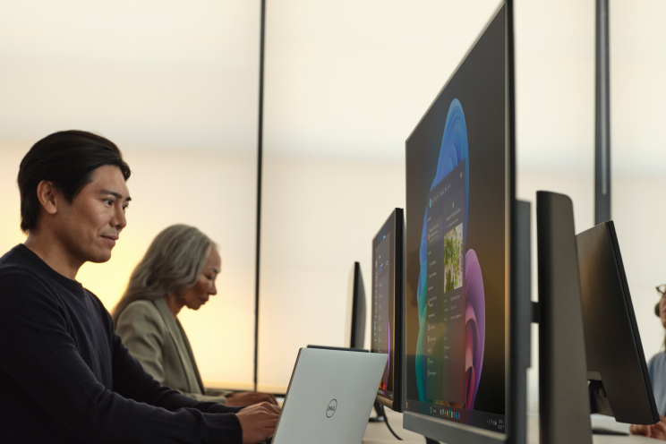 People working in front of large monitors.