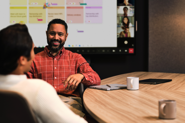 Two people seated at a conference table.